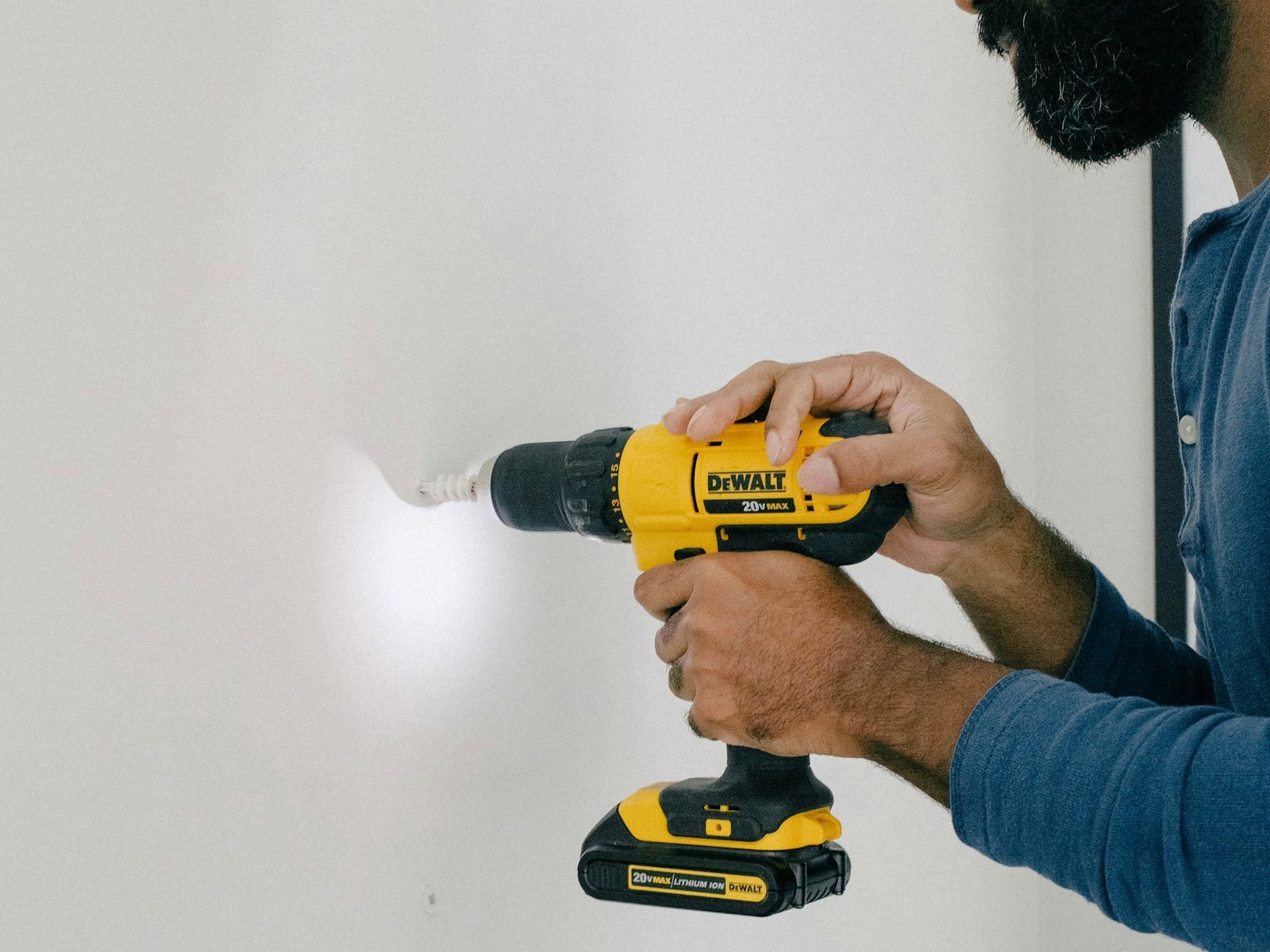 Installer drilling a plasterboard wall for the bracket